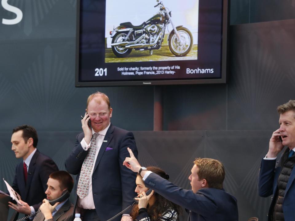 Auction officers on the phone during the auction of the 2013 Harley Davidson Super Glide Custom A 1,585cc which was donated to Pope Francis last year, in Paris, Thursday Feb. 6, 2014. Pope Francis' Harley-Davidson is hitting the road after an unspecified European buyer agreed to pay 241,500 euros ($327,000) including taxes and fees for the motorcycle at a Paris auction to benefit charity. The Bonhams auction house said the telephone buyer agreed to pay far more than the expected pre-sale price of more than 12,000 euros ($16,000) at the auction at Paris' Grand Palais. (AP Photo/Jacques Brinon)