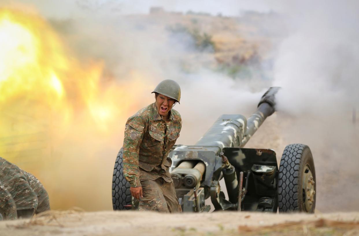 An Armenian serviceman fires a cannon towards Azerbaijan positions in the Nagorno-Karabakh region (AP)