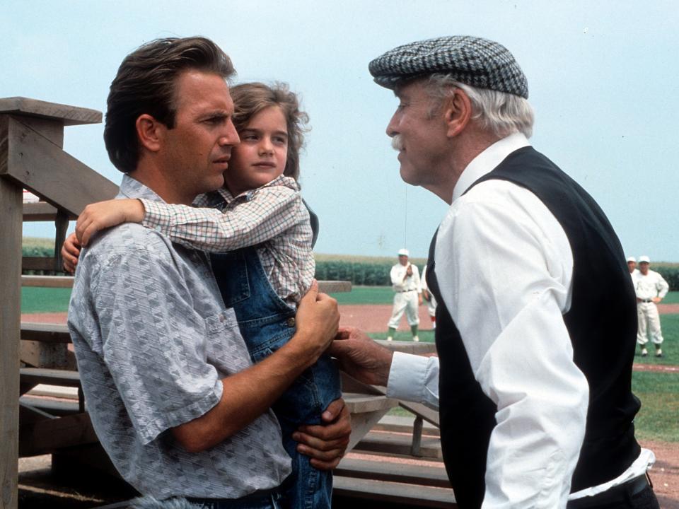 Kevin Costner holding Gaby Hoffmann in a scene from the film 'Field Of Dreams', 1989.