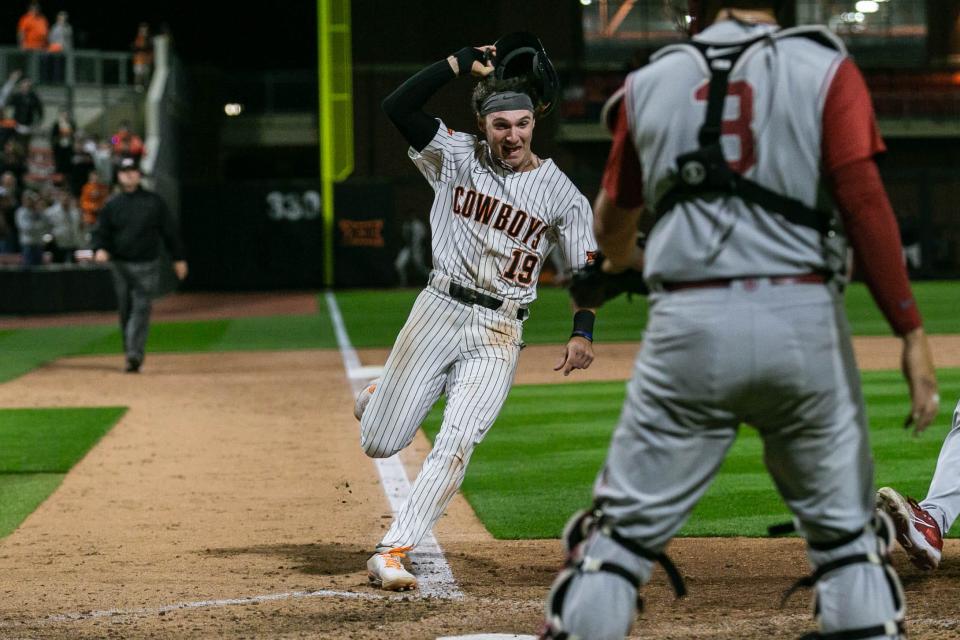 Marcus Brown (19) scores the winning run as OSU beat OU 8-7 Saturday night at O'Brate Stadium in Stillwater.