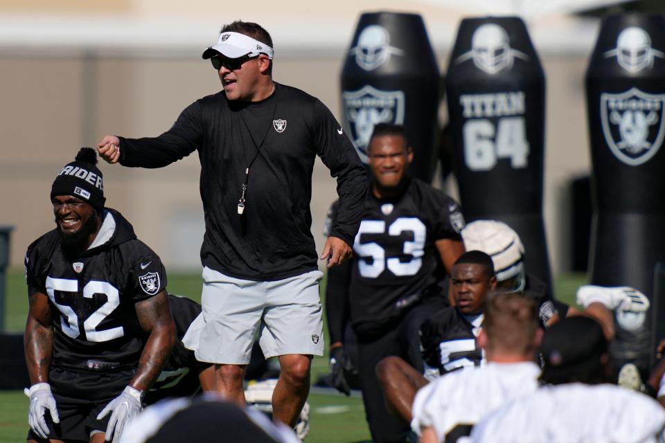 Raiders head coach Josh McDaniels speaks with players during training camp, July 21, 2022, in Henderson, Nev.