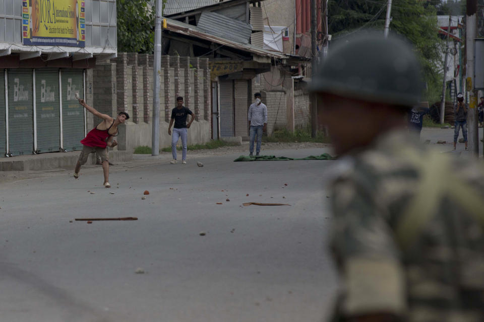 Kashmiri Muslim protesters throw stones at Indian paramilitary soldiers during curfew like restrictions in Srinagar, India, Friday, Aug. 16, 2019. Hundreds of Kashmiris held a street protest in the Indian-controlled Kashmir even as India's government assured the Supreme Court on Friday that the situation in disputed Kashmir is being reviewed daily and unprecedented security restrictions will be removed over the next few days, an attorney said after the court heard challenges to India's moves. (AP Photo/Dar Yasin)