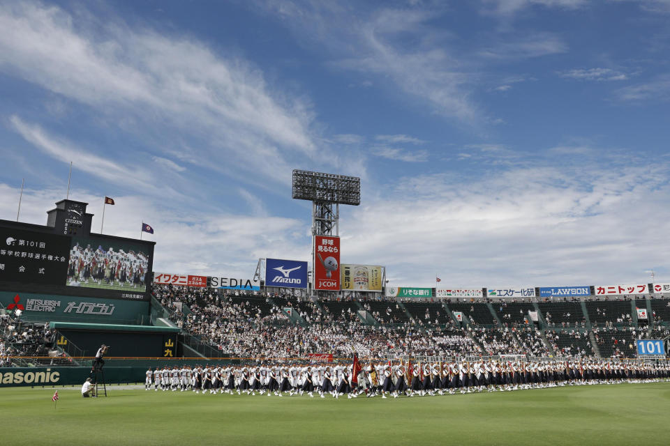 In this Aug. 2019, photo, baseball players parade during the opening ceremony of the summer high school baseball tournament at Koshien stadium in Nishinomiya, western Japan. Japan’s beloved baseball tournament was canceled on Wednesday, May 20, 2020, because of the coronavirus pandemic. (Kyodo News via AP)