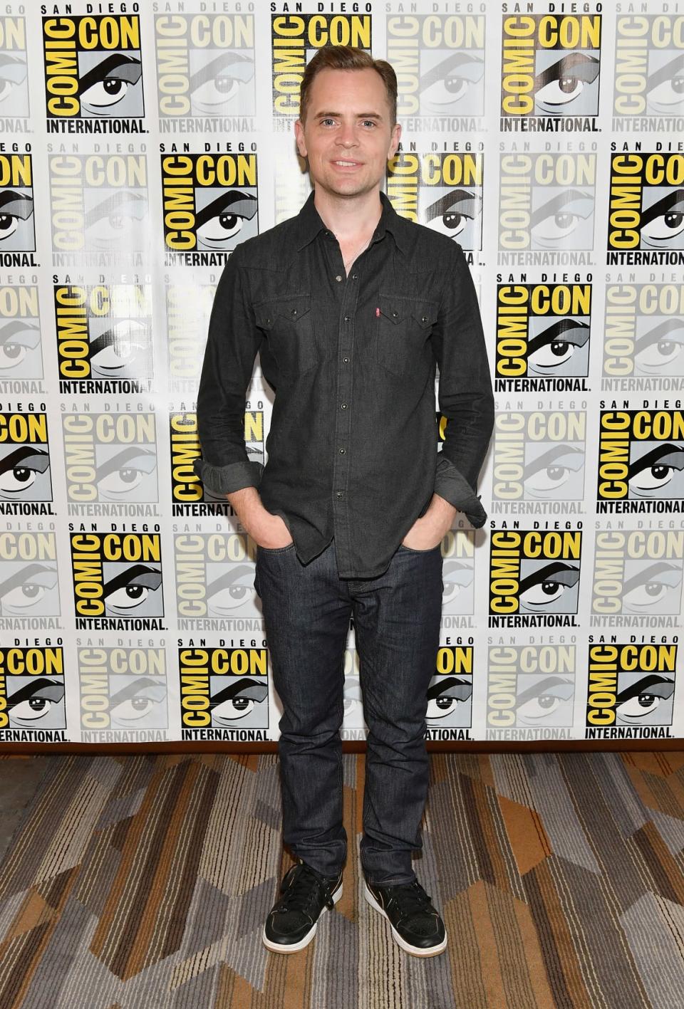 David Jenkins standing in front of a stand and repeat at Comic Con