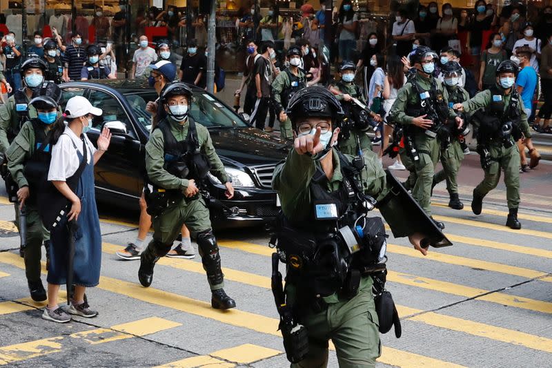 Riot police chase pro-democracy protesters during a demonstration oppose postponed elections, in Hong Kong