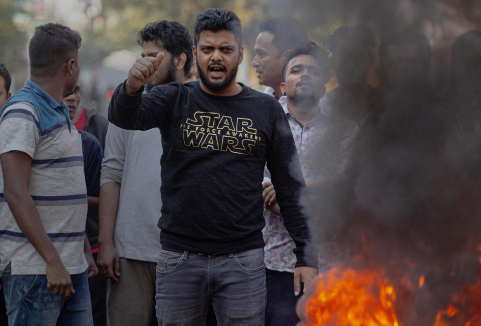 Indian protesters shout anti Citizenship Amendment Bill (CAB) slogans as they burn tires on a road during a shutdown protest in Gauhati, India, Tuesday, Dec. 10, 2019. Opponents of legislation that would grant Indian citizenship to non-Muslim illegal migrants from Pakistan, Bangladesh and Afghanistan have enforced an 11-hour shutdown across India's northeastern region. (AP Photo/Anupam Nath)