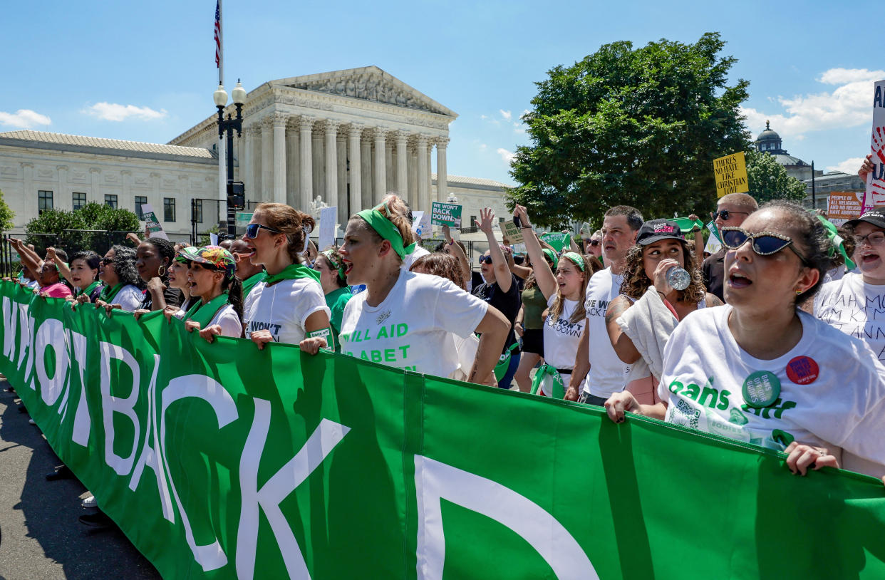 Abortion rights activists march past the Supreme Court.