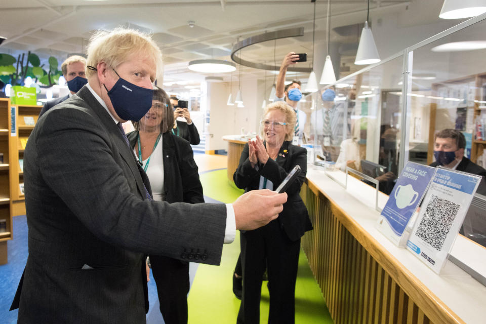 Prime Minister Boris Johnson scans his NHS Coronavirus App at Uxbridge Library during a walkabout where he met shoppers and shopkeepers in his constituency of Uxbridge, west London.