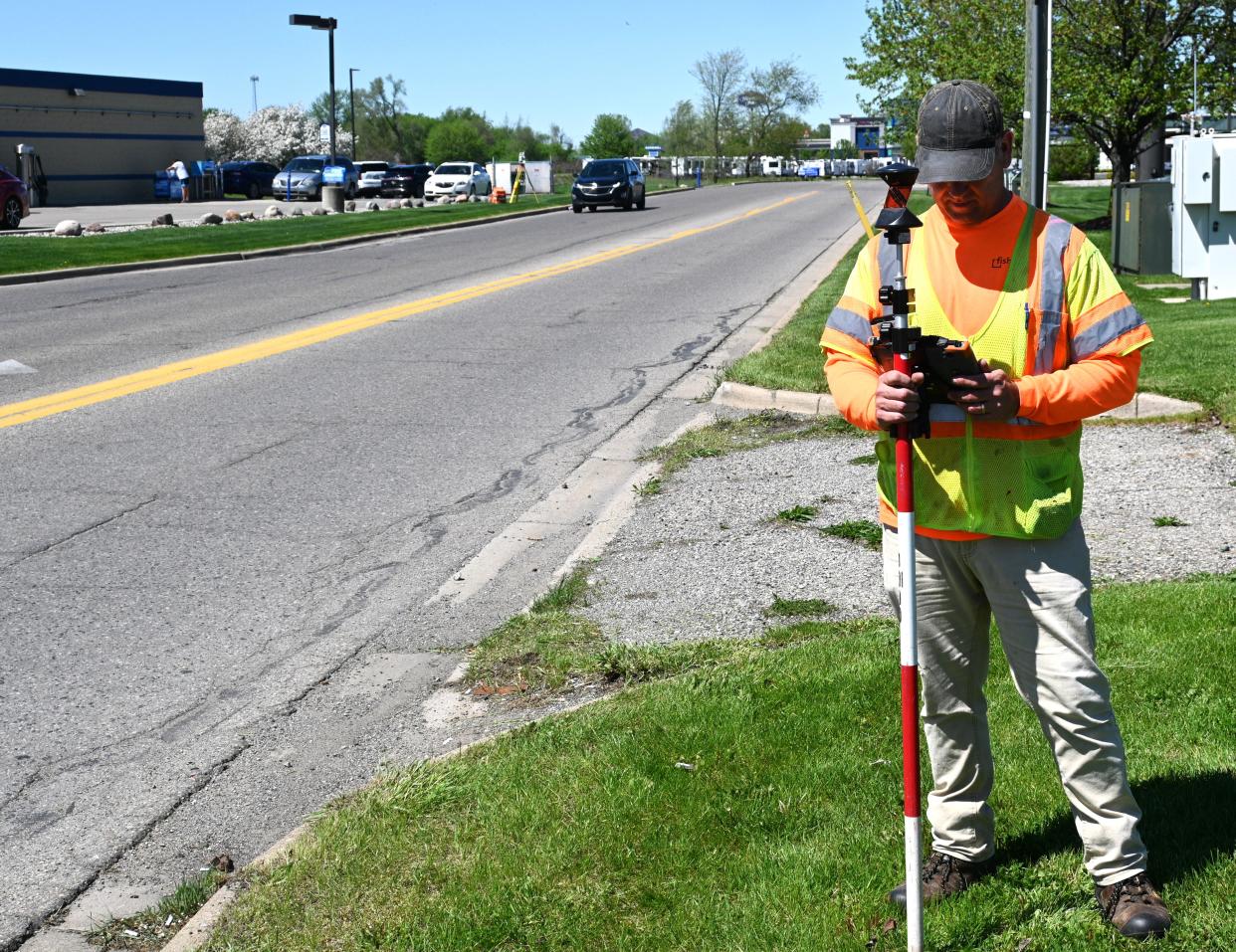 Fishbeck senior surveyor Scott Hopkins Tuesday surveyed possible locations for a sidewalk along N. Willowbrook Road.