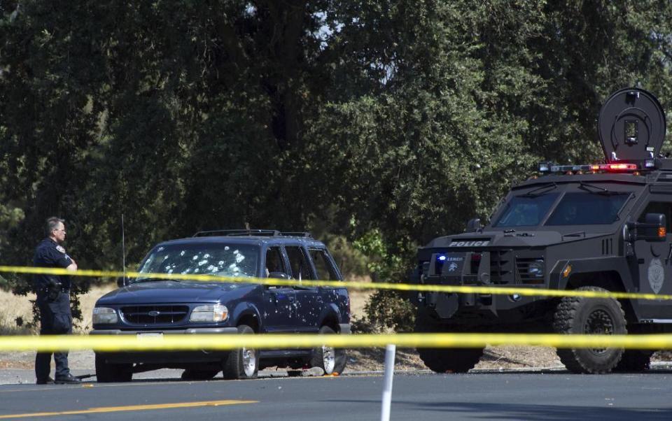 FILE - In this July 16, 2014, a Stockton Police officer investigates the scene after a vehicle involved in a suspected bank robbery was stopped in Stockton, Calif. The California man, Jaime Ramos, who used a woman he took hostage to shield himself from a spray of bullets fired by officers following a deadly bank robbery and car chase , is scheduled to be sentenced Tuesday, Feb. 21, 2017. (Craig Sanders/The Record via AP, File)