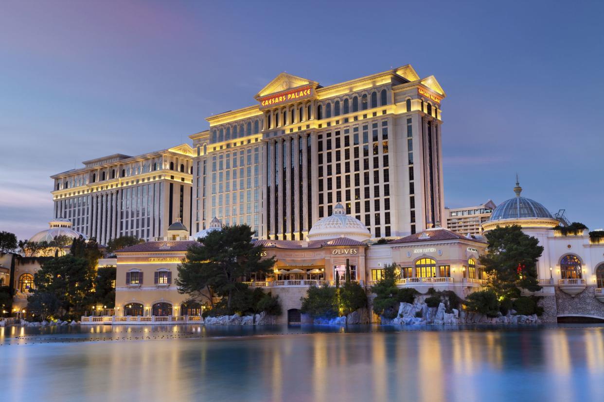 hotel Caesars Palace at twilight, located at the Paradise area in the Las Vegas Strip, as seen over the Bellagio Lake