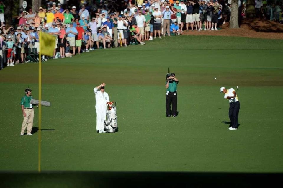 Tiger Woods hits his second approach shot to the 15th green after making a drop during the second round of the 2013 Masters Tournament at Augusta National Golf Club on Friday, April 12, 2013, in Augusta, Ga. (MICHAEL HOLAHAN/STAFF)