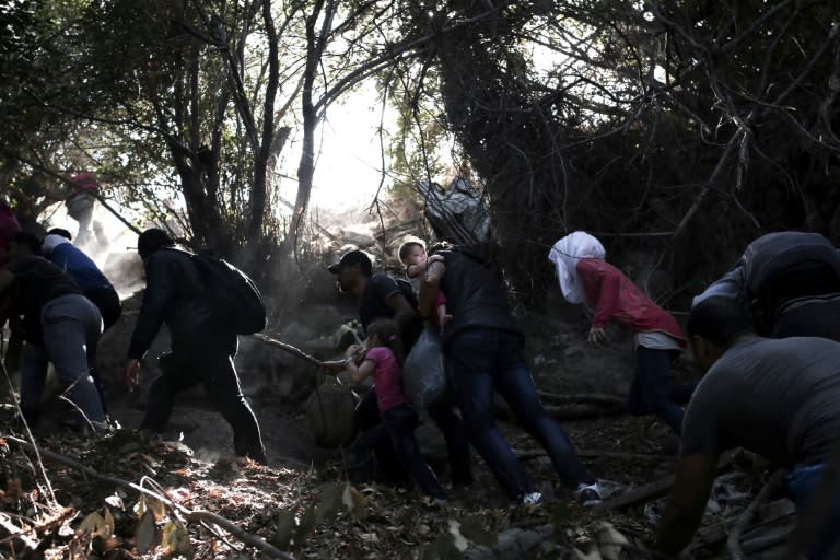 Syrian refugees climb a slope after arriving from Turkey on the shores of the Greek island of Lesbos in an inflatable dinghy on September 11, 2015