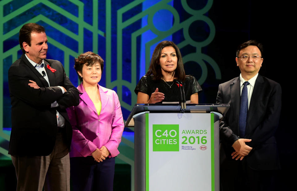 BYD executive Stella Li (second from the left) poses next to Brazilian Eduardo Paes; Anne Hidalgo, mayor of Paris; and Wang Chuan-Fu, chairman and President-CEO of BYD, at the Palacio de Mineria in Mexico City, on Dec. 1, 2016. (ALFREDO ESTRELLA/AFP via Getty Images)
