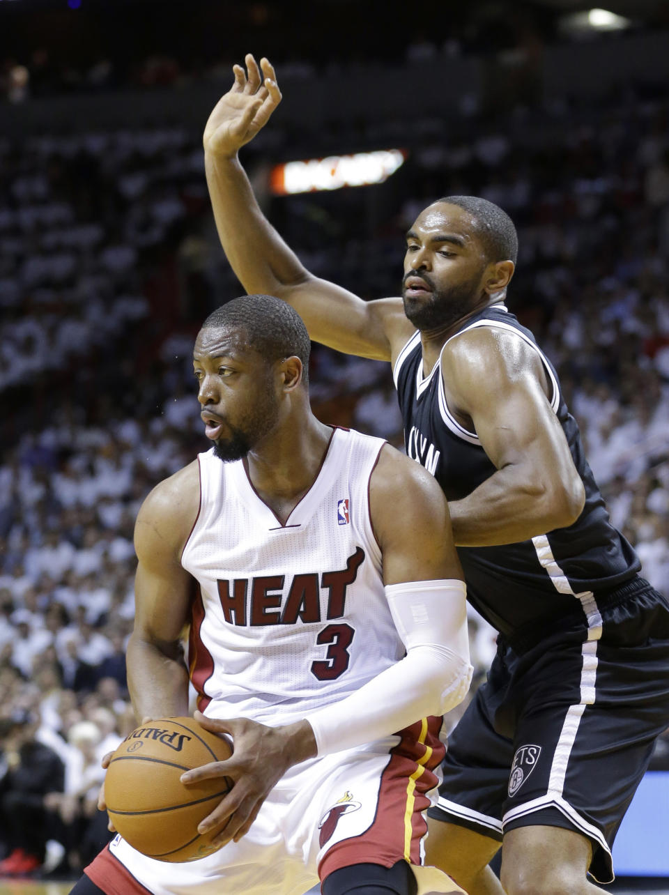 Miami Heat guard Dwyane Wade (3) looks for an open teammate as Brooklyn Nets forward Alan Anderson (6) defends during the first half of Game 2 of an Eastern Conference semifinal basketball game, Thursday, May 8, 2014 in Miami. (AP Photo/Wilfredo Lee)