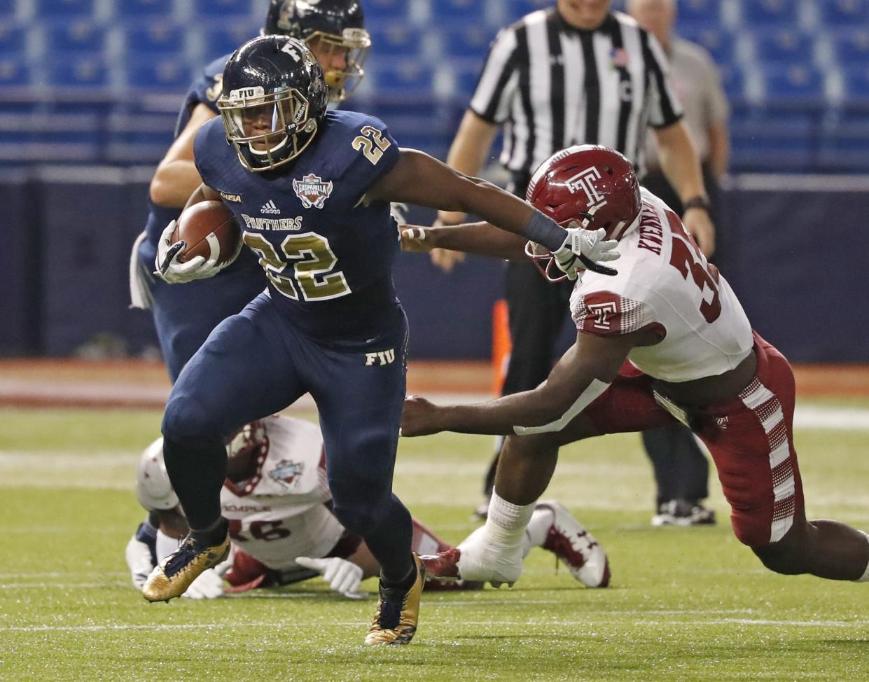 FIU running back Shawndarrius Phillips (22) carries as Temple linebacker William Kwenkeu (35) reaches for him during the Gasparilla Bowl NCAA college football game Thursday, Dec. 21, 2017, in St. Petersburg, Fla. (Al Diaz/Miami Herald via AP)