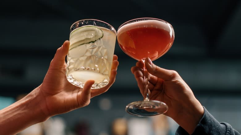 Two people holding cocktails