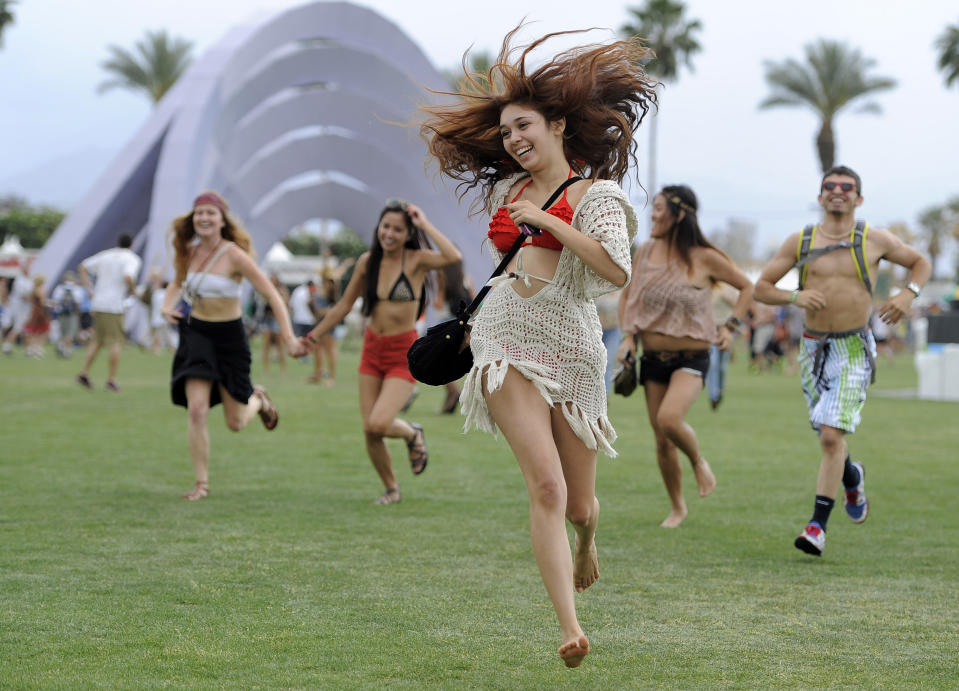 FILE - This April 13, 2012 file photo shows festivalgoers running toward the main stage at the 2012 Coachella Valley Music and Arts Festival in Indio, Calif. The Coachella music festival in Southern California has been postponed amid virus concerns. The festival is organized by concert promoter Goldenvoice, which released a statement Tuesday saying it will be rescheduled for two weekends in October. For most people, the new coronavirus causes only mild or moderate symptoms, such as fever and cough. For some, especially older adults and people with existing health problems, it can cause more severe illness, including pneumonia. The vast majority of people recover from the new virus. According to the World Health Organization, people with mild illness recover in about two weeks, while those with more severe illness may take three to six weeks to recover. (AP Photo/Chris Pizzello, File)