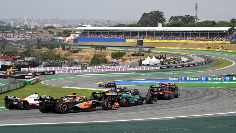 The F1 field driving through the left-handed first corner at Interlagos in Brazil.