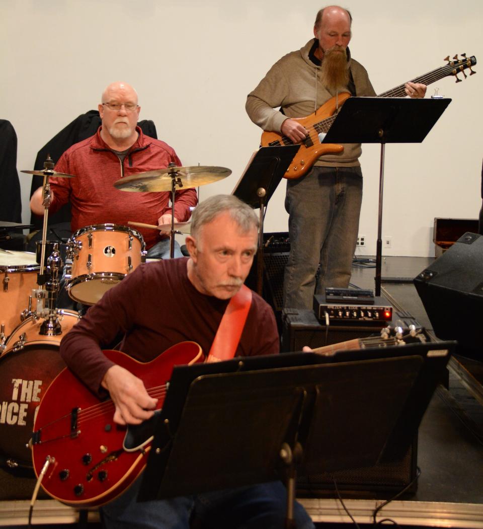 Pictured from front to back, Philip Eversden on guitar, Joe Tuckey on drum set and Dana Gillin on bass rehearse for the TCA Big Band and VocalAires' concert May 15.