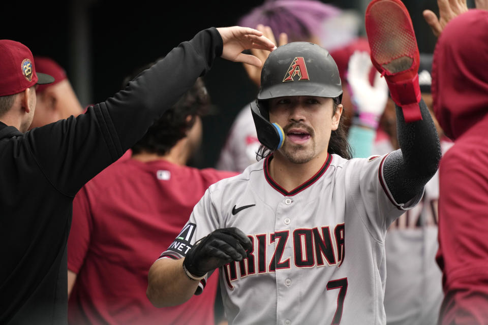 Arizona Diamondbacks' Corbin Carroll is greeted in the dugout after scoring during the ninth inning of a baseball game against the Detroit Tigers, Sunday, June 11, 2023, in Detroit. (AP Photo/Carlos Osorio)