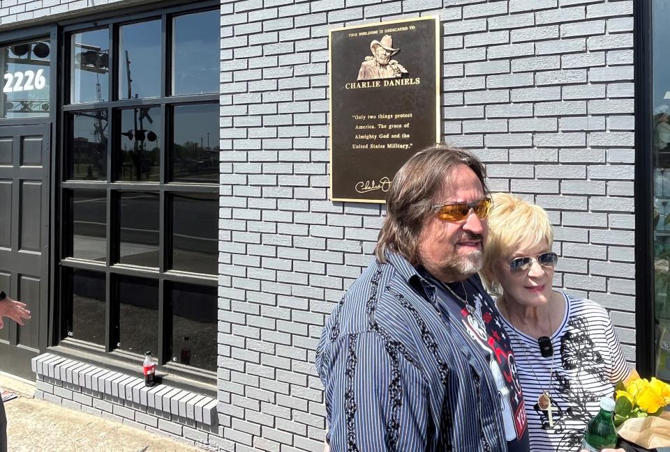 Charlie Daniels Jr. left and Hazel Daniels, right in front of a plaque that pays tribute to Charlie Daniels in Mt. Juliet.