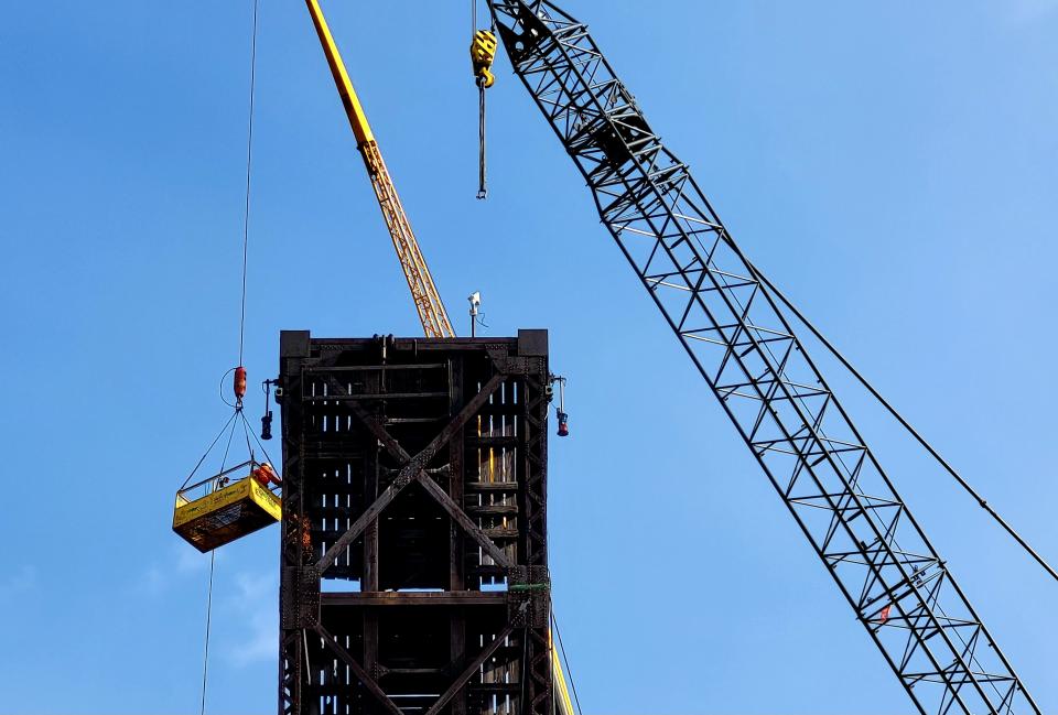 Sparks fly as crews begin to saw into part of the steel Pere Marquette Rail Bridge Tuesday, March 21, 2023. The bridge later briefly caught fire.