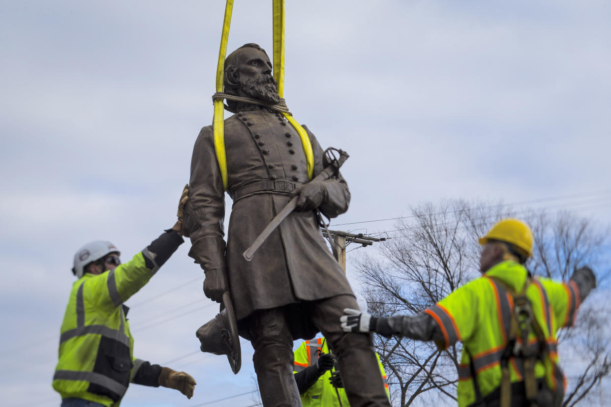 Workers begin to put the bronze statue of Confederate Gen. A.P. Hill onto a flatbed truck in Richmond, Va.  