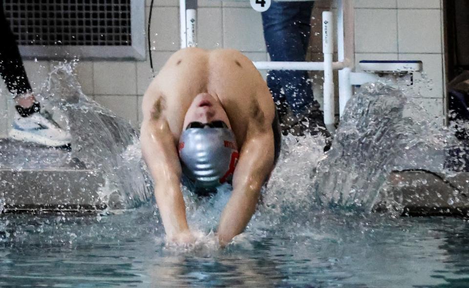 Bedford's Nick Zoldowski enters the water at the start of the 100-yard backstroke during the Monroe County Championship Saturday, February 4, 2023 at Dundee High School.