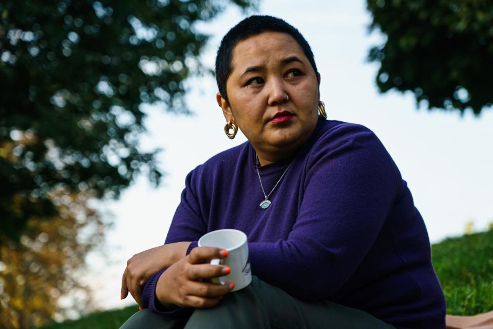 Woman holds coffee cup in park