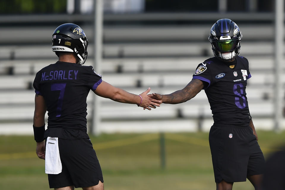 Baltimore Ravens quarterback Lamar Jackson, right, greets Trace McSorley during an NFL football practice, Monday, Aug. 9, 2021 in Owings Mills, Md.(AP Photo/Gail Burton)