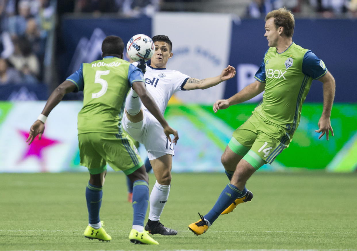 Fredy Montero and the Vancouver Whitecaps attack was stifled by Chad Marshall (right) and the Seattle Sounders. (Darryl Dyck/The Canadian Press via AP)