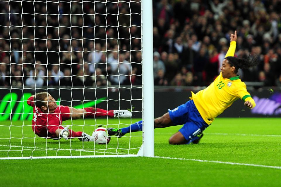 England goalkeeper Joe Hart denies Brazil's Gaucho Ronaldinho (right) for a second time after saving his initial penalty