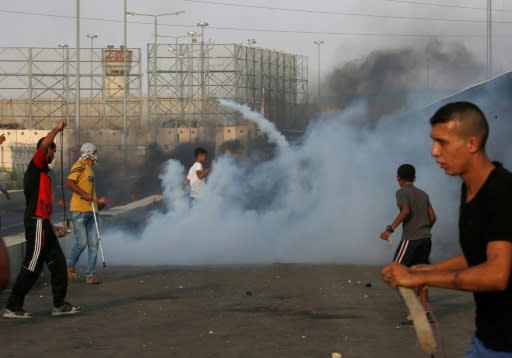 Palestinian protesters demonstrate amid tear gas fired by Israeli troops at the Erez border crossing with Israel in the northern Gaza Strip on October 3, 2018