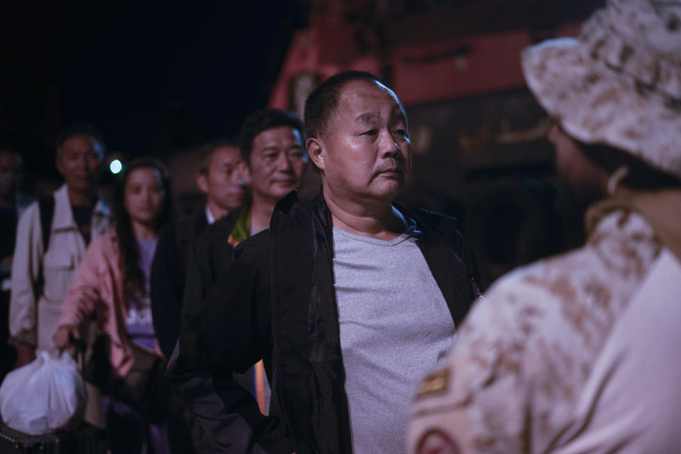 Chinese evacuee Liu Dongsheng, 58, is checked by a Saudi commando before boarding a Saudi military ship to Jeddah port, at Port Sudan, in Sudan, late Tuesday, May 2, 2023. Many are fleeing the conflict in Sudan between the military and a rival paramilitary force. (AP Photo/Amr Nabil)