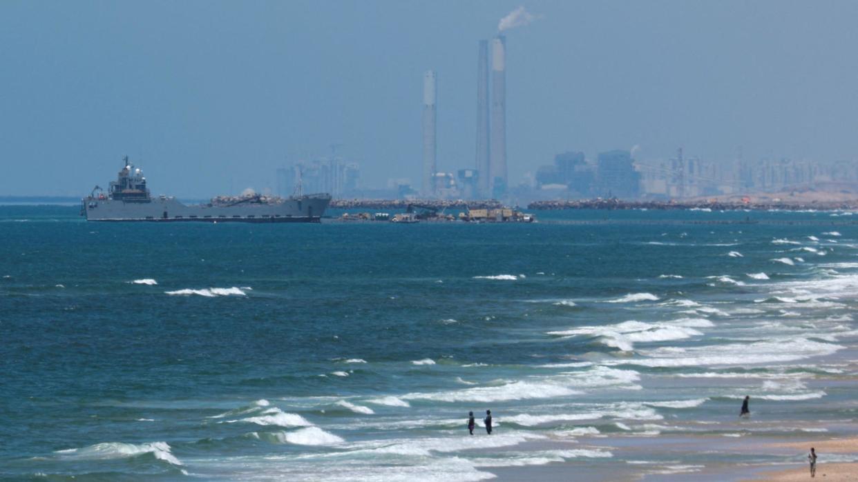 A ship is pictured off the coast of Gaza near a temporary floating pier anchored to a beach by the US military (16 May 2024)