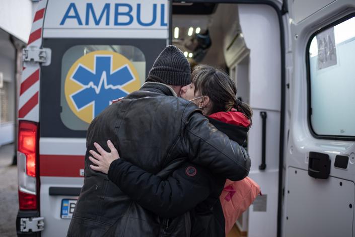 A man hugs his wife next to an ambulance car that would evacuate her and her daughter to Poland on March 19, 2022 in Lviv, Ukraine.
