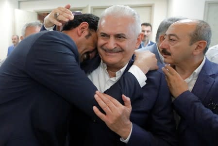 Binali Yildirim, mayoral candidate of the ruling AK Party, is greeted by a supporter at his party's Istanbul headquarters in Istanbul