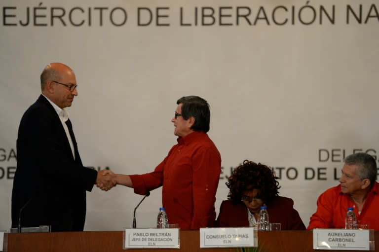 Colombia's National Liberation Army (ELN) delegate Pablo Beltran (R) shakes hand with the head of the government delegation, Mauricio Rodriguez, in Caracas