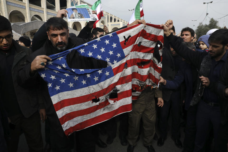 Protesters burn a U.S. flag during a demonstration over the U.S. airstrike in Iraq that killed Iranian Revolutionary Guard Gen. Qassem Soleimani, in Tehran, Iran, Jan. 3, 2020. Iran has vowed "harsh retaliation" for the U.S. airstrike near Baghdad's airport that killed Tehran's top general and the architect of its interventions across the Middle East, as tensions soared in the wake of the targeted killing. (AP Photo/Vahid Salemi)