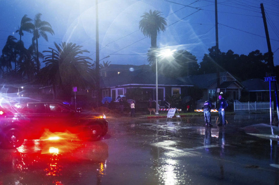 Police officers notify residents of rising floods during a rainstorm on Sunday, Feb. 4, 2024, in Santa Barbara, Calif. / Credit: Ethan Swope / AP