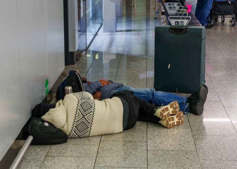 Travelers lie sleeping on the floor at Frankfurt Airport, one of 11 major German airports that have started a one-day strike. Andreas Arnold/dpa