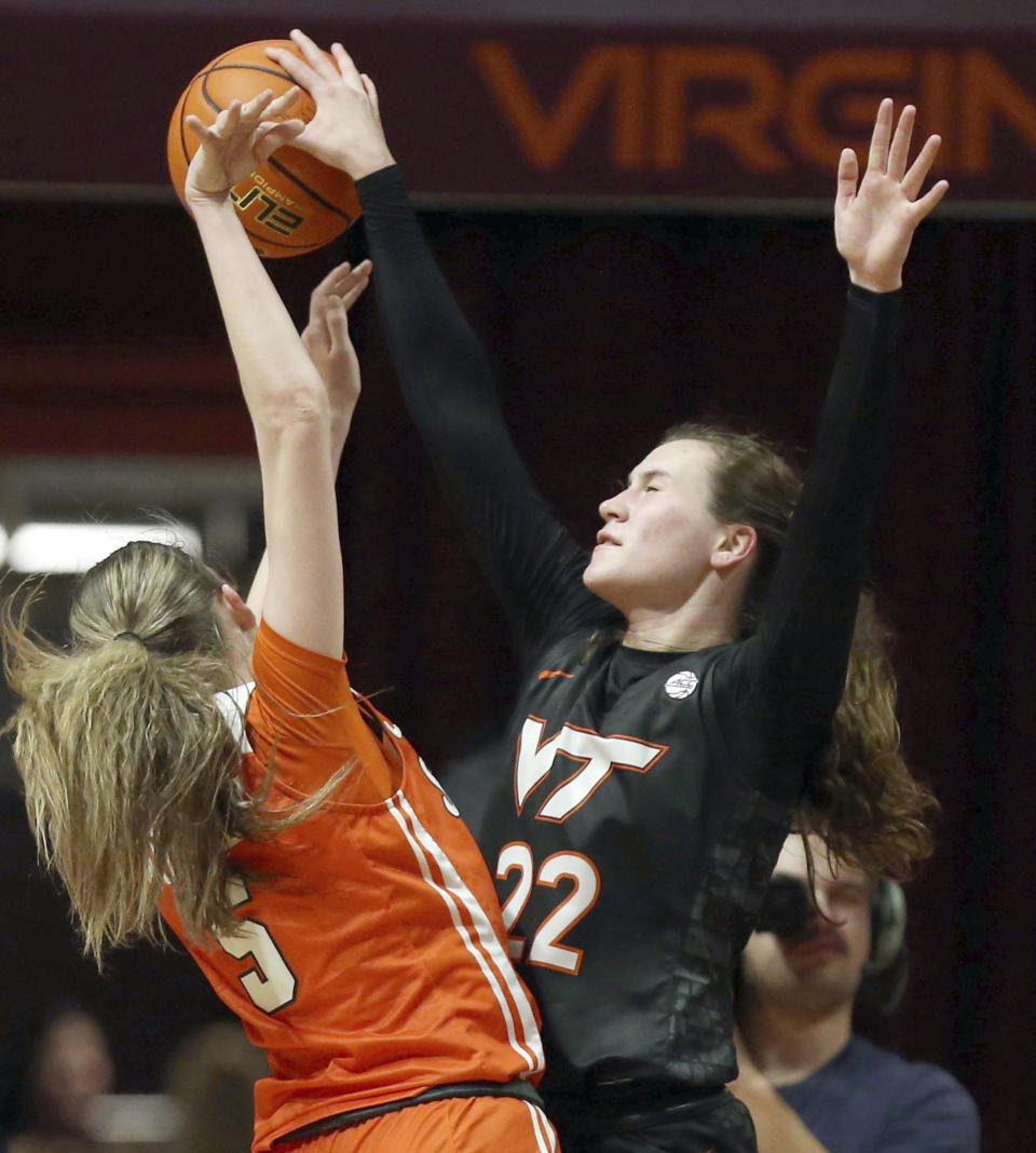 Syracuse's Georgia Woolley, left, has her shot blocked by Virginia Tech's Cayla King (22) during the first half of an NCAA college basketball game in Blacksburg, Va., Thursday, Feb. 2, 2023. (Matt Gentry/The Roanoke Times via AP)