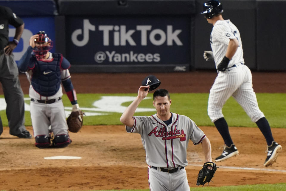 Atlanta Braves relief pitcher Nate Jones center, removes his cap and turns away from the plate as New York Yankees DJ LeMahieu scores on a walk during the eighth inning of an interleague baseball game, Tuesday, April 20, 2021, at Yankee Stadium in New York. Atlanta Braves catcher Travis d'Arnaud is at left. (AP Photo/Kathy Willens)