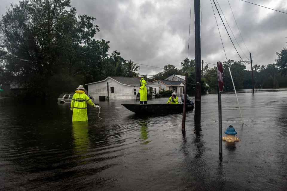 Workers with Duke Energy move through Lumberton by boat in an effort to restore power to customers on Sunday after intense flooding in the town.