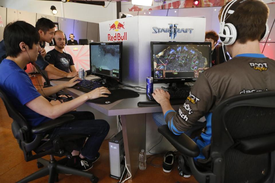 In this photo taken Friday, June 21, 2013, legendary "WarCraft 3" player, Jo "Golden" Myeong Hwan, from South Korea, left, joins seven of the world's best "StarCraft II" video game players to train at Red Bull Training Grounds, held at Red Bull North America headquarters in Santa Monica, Calif. The Red Bull TV e-sports series included live-streamed scrimmages and a tournament with $8,600 in prize money. (AP Photo/Damian Dovarganes)