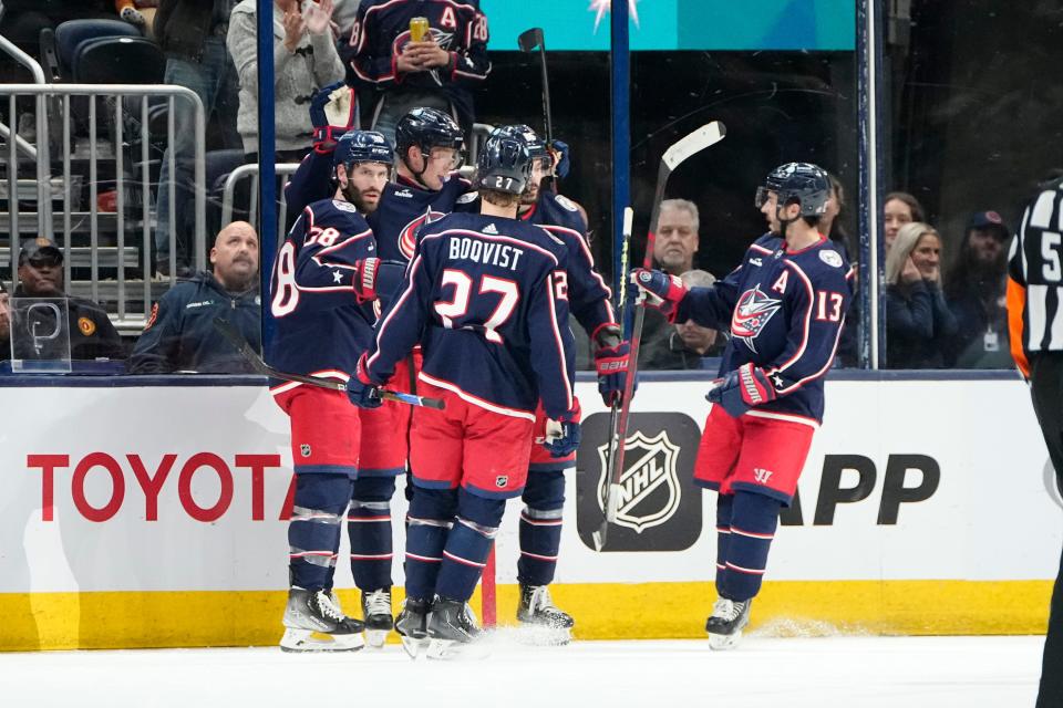 Teammates celebrate a goal by Blue Jackets wing Patrik Laine on Friday.