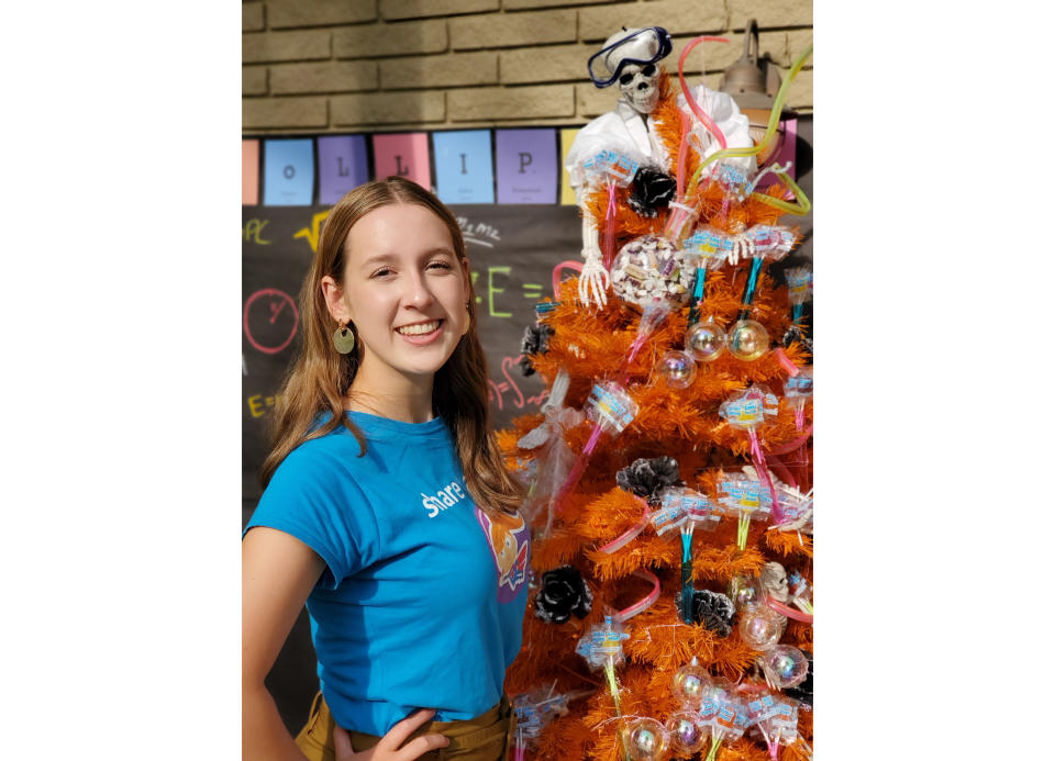 En esta imagen proporcionada por Zolli Candy, la emprendedora de dulces Alina Morse, de 15 años, posa junto a un árbol decorado para Halloween. (Klint Briney/Zolli Candy vía AP)