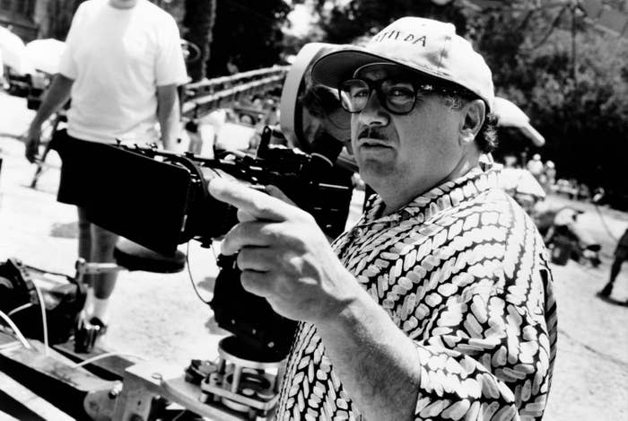 Danny DeVito stands next to a camera