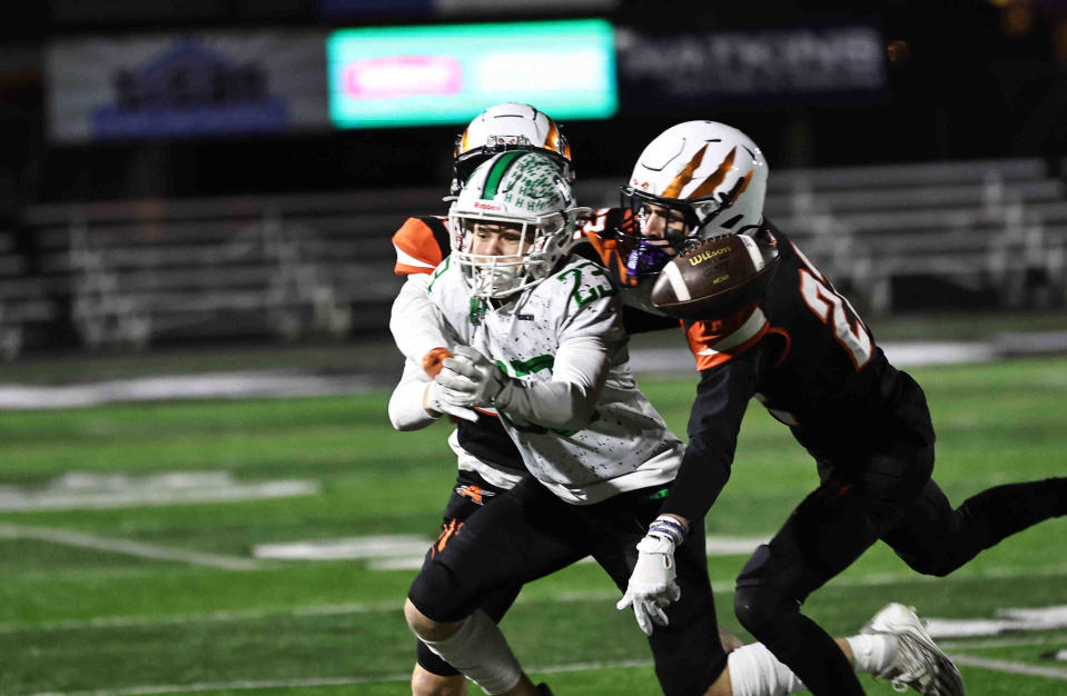 Anderson defenders Leo Muehlenkanp (22) and Patterson McHugh (29) knock the ball away from Harrison wide receiver Cooper Rotert (23) during their playoff game Friday, Nov. 10, 2023.